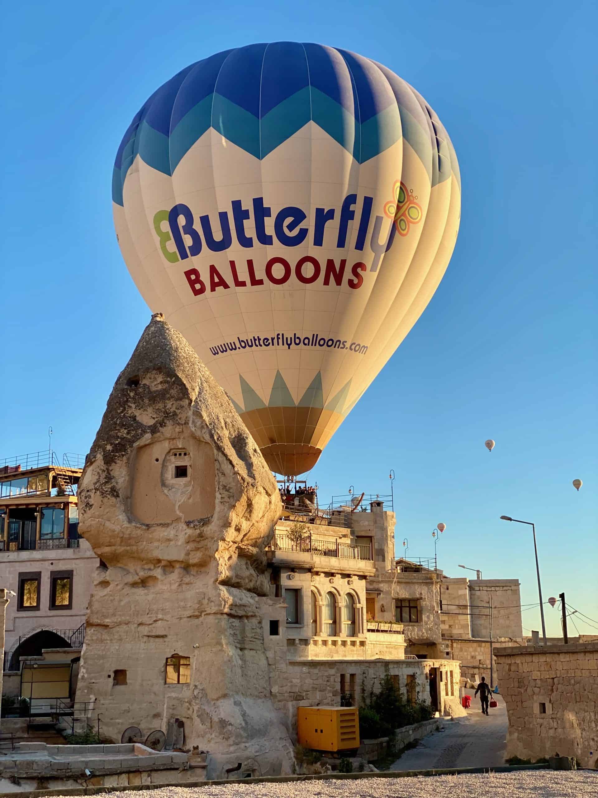 Hot air balloon playfully hovering over a rooftop in Göreme